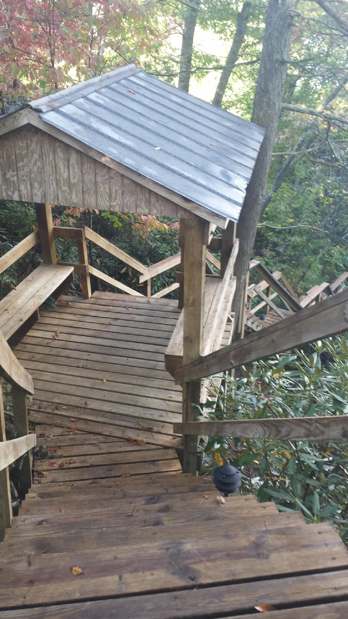 Metal roofed shelter over wooden steps on a wooded walkway — Skylight Repair & Installation work by our crew in Fountain Run