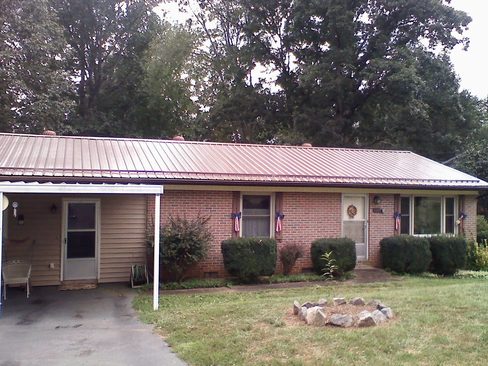 Bronze metal roof and carport on a brick ranch home — Roof Repair work by our crew in Fountain Run
